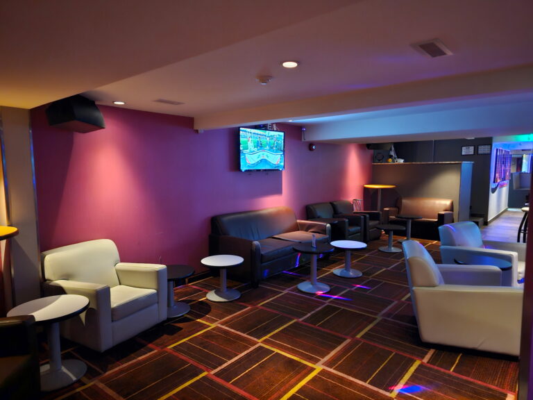 Seating area with colourful lighting inside Alley Katz Windsor